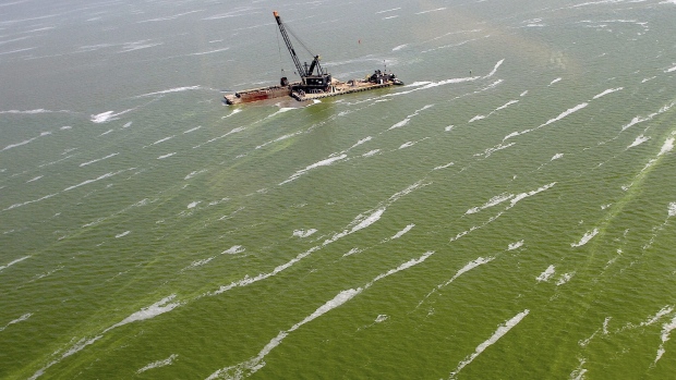 A dredge barge works along the edge of a large algae bloom in the Toledo shipping channel in Toledo, Ohio, in August 2013. Phosphorus run-off from agriculture is a threat to the lake's future.