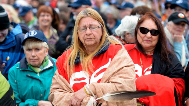 Debbie Stephens holds an eagle feather as she pauses before the start of the walk for reconciliation, part of the closing events of the Truth and Reconciliation Commission on Sunday in Gatineau, Que.