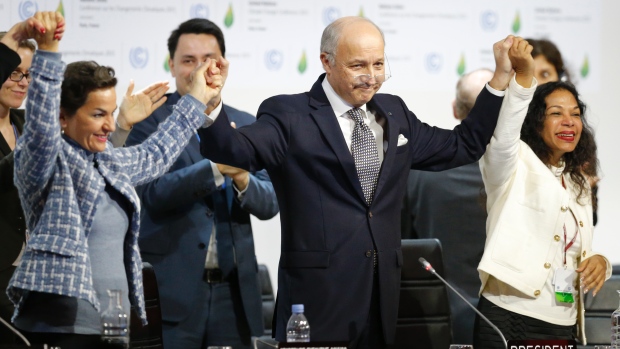 French Foreign Affairs Minister Laurent Fabius, centre, who chaired the Paris climate talks, and Christiana Figueres, left, executive secretary of the UN Framework Convention on Climate Change, celebrate at the close of the summit on Saturday, Dec. 12, 2015. 