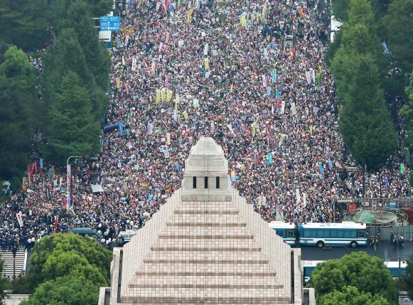 People hold placards and shout slogans as they gather to protest against Japan's Prime Minister Shinzo Abe's security bill outside the parliament in Tokyo, in this photo taken by Kyodo August 30, 2015. REUTERS/Kyodo