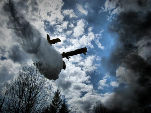 A plane drops a water bomb on a forest fire in Ontario, Canada Image: {Per via Wikimedia Commons